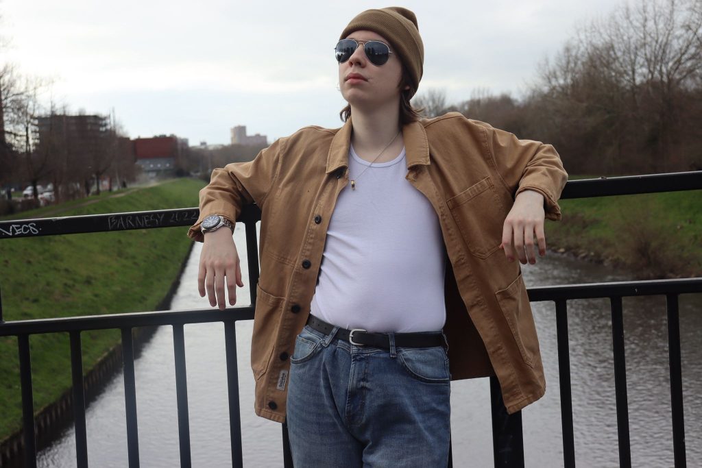 Joe leaning on a bridge's railings over a river.