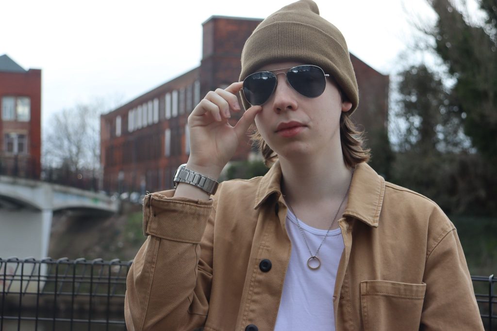 Joe holding up his glasses in front of an old building.