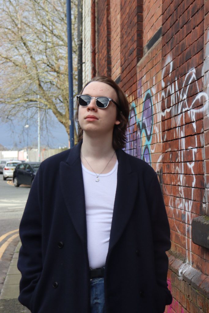 Joe gazing at the sky next to a wall.