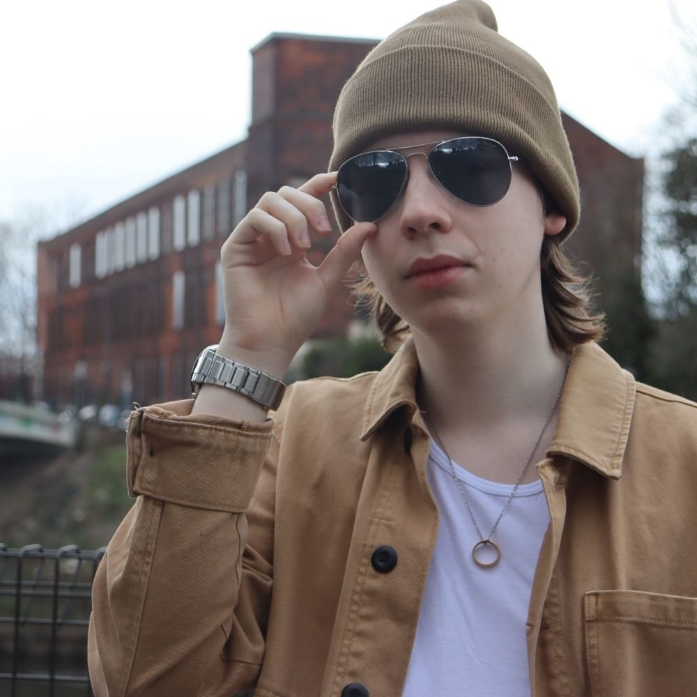 Joe holding up his glasses in front of an old building.